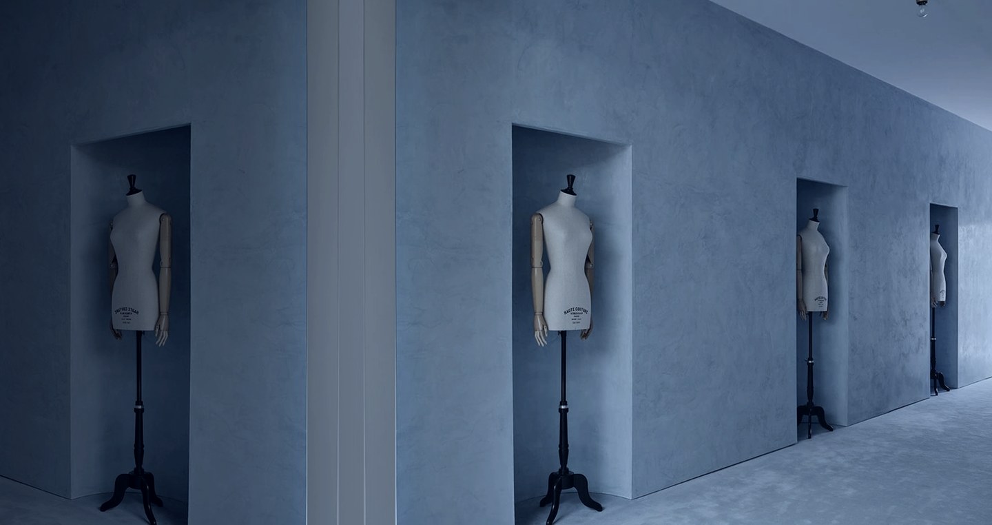 Dress forms set into niches along a blue plaster wall, choosing a distribution partner for a fashion brand