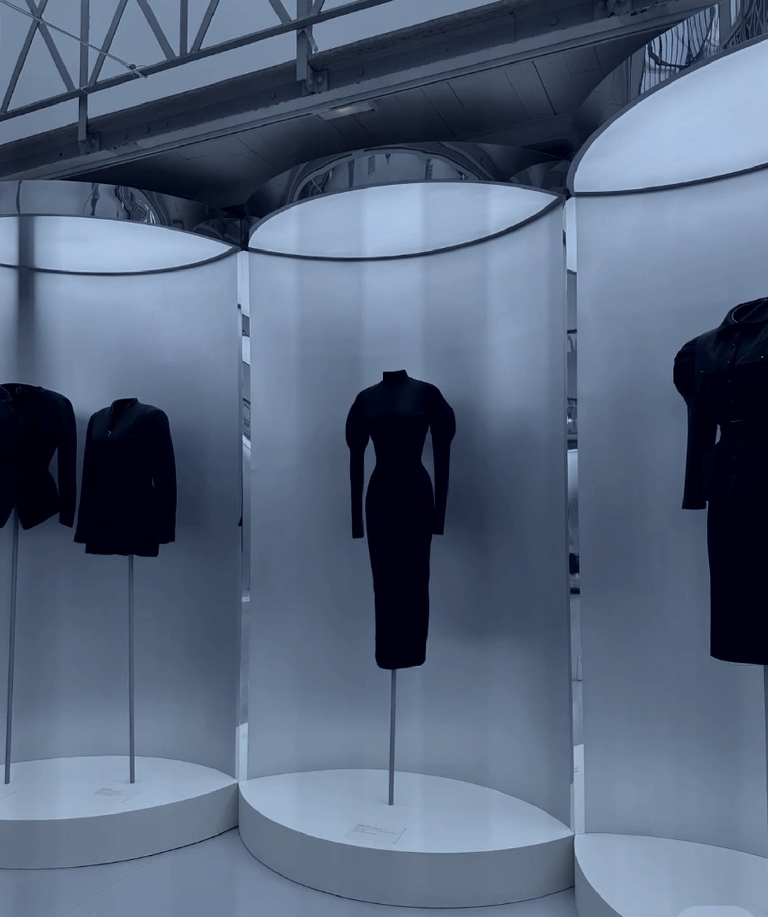 Tailoring displayed in frosted cylindrical vitrines, retail activations for a fashion brand