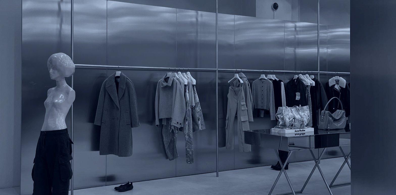 A brushed steel interior with a rail of outerwear, fashion retailer placement matched to the room