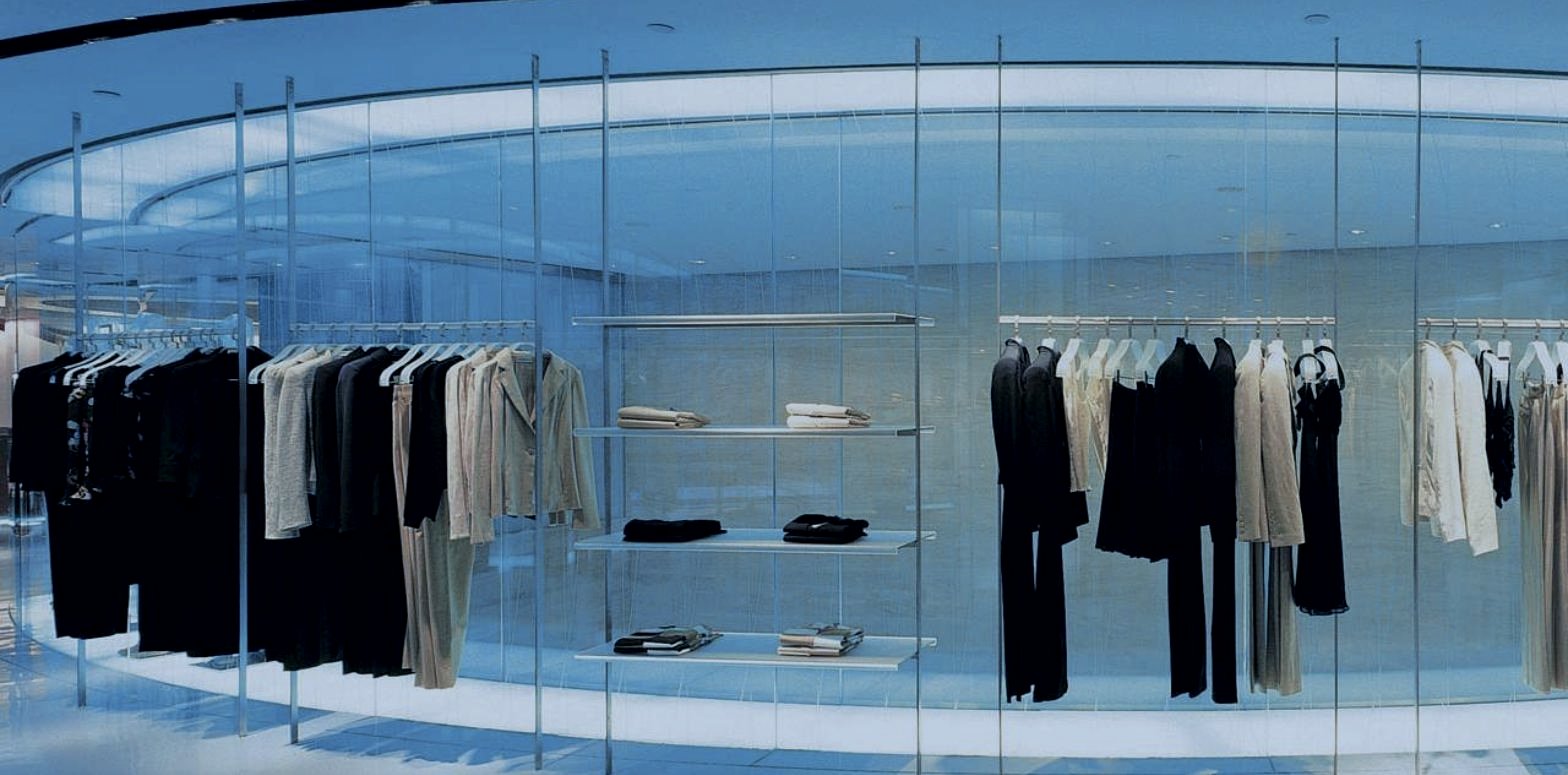 A collection presented behind curved glass in a showroom, fashion wholesale strategy by DE Agency