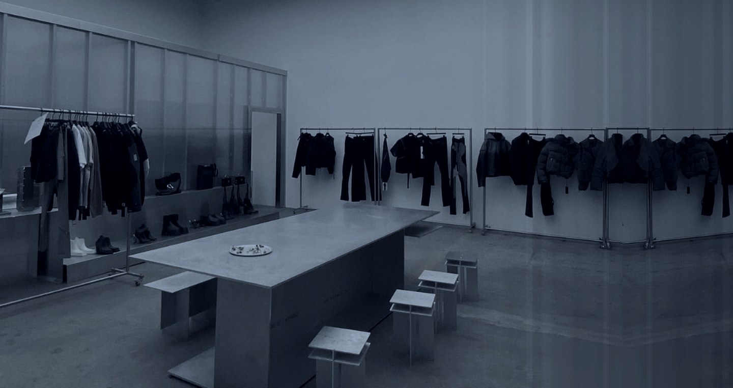 A showroom of rails and a steel presentation table, fashion wholesale pricing and order terms